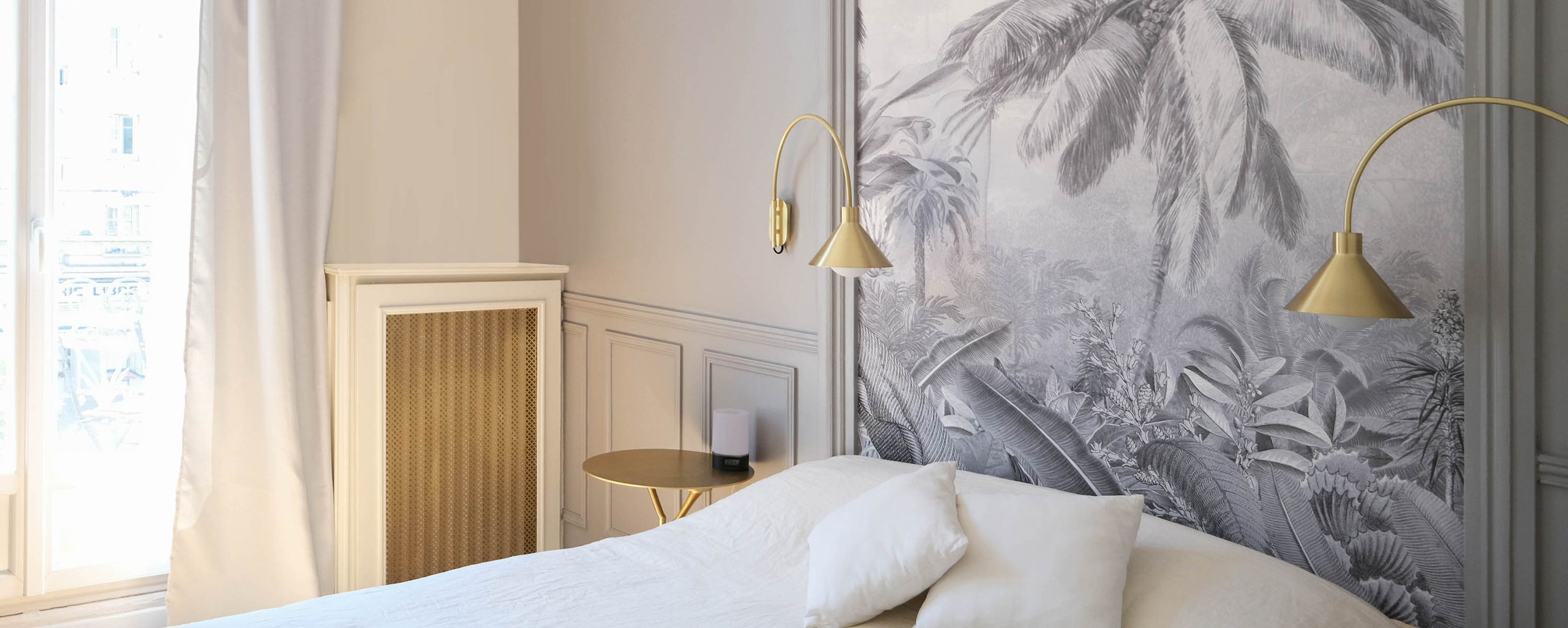 Chambre rénovée avec papier peint panoramique végétal et décoration intérieure élégante pour le projet Poniatovski à Paris.