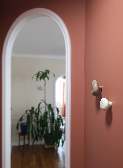 Rénovation d’appartement à Saint Mandé avec arche murale, patères en porcelaine cristallisée et palette terracotta pensée pour un intérieur chaleureux et apaisant.