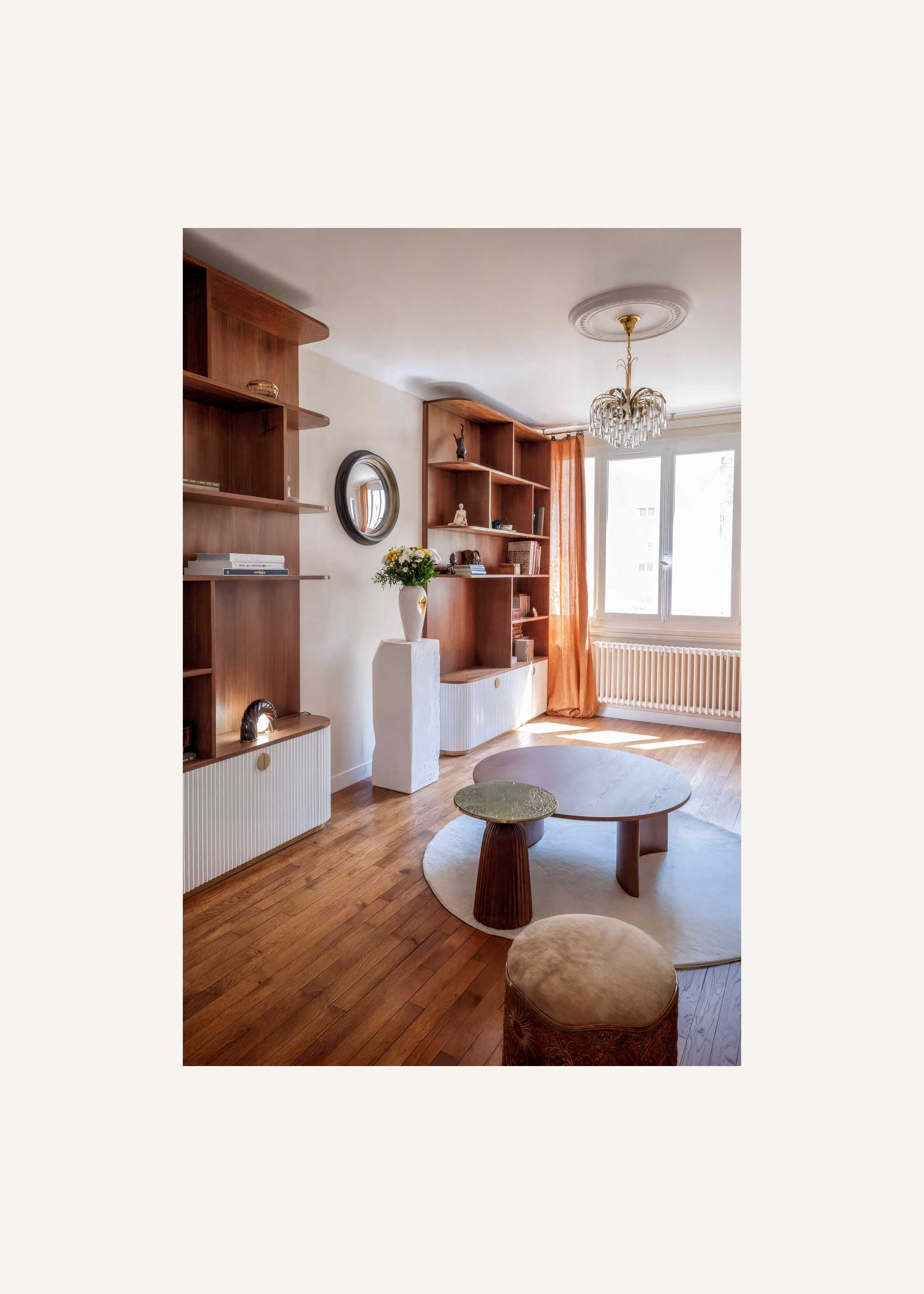 Salon rénové à Saint Mandé avec bibliothèque sur mesure en noyer, rangements cannelés, création de mobilier sur mesure pour une décoration intérieure unique et organique.