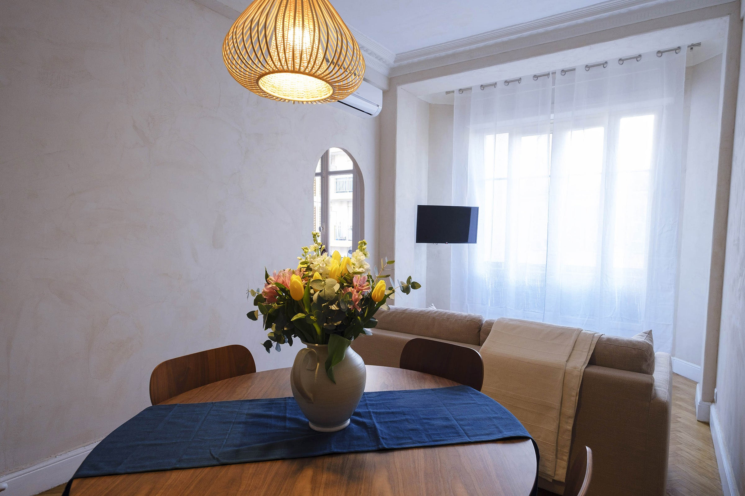 Salon et salle à manger avec espace repas optimisé et décoration minimaliste. Design d'espace à Nice dans un appartement ancien.