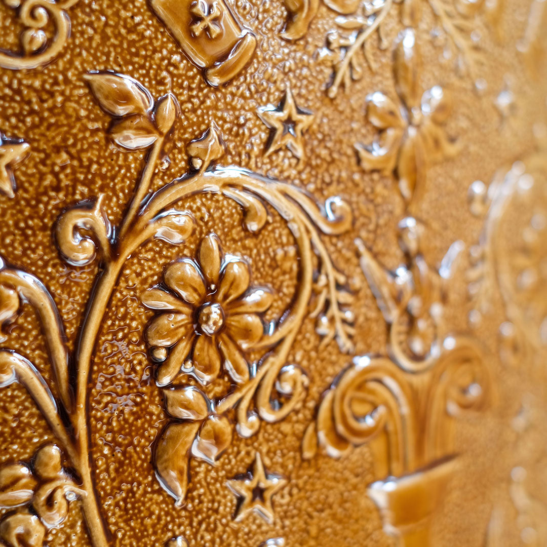 Détail de la gravure florale et des étoiles sur la faïence émaillée du tabouret Visconti, Ombre d'Or.