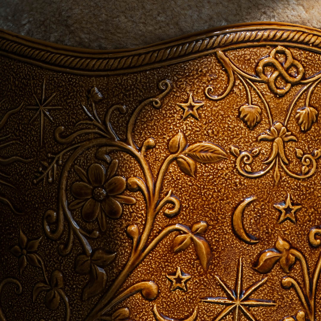 Détail du bord torsadé et des motifs floraux, étoiles et croissant de lune gravés sur la faïence du tabouret Visconti, Ombre d'Or.