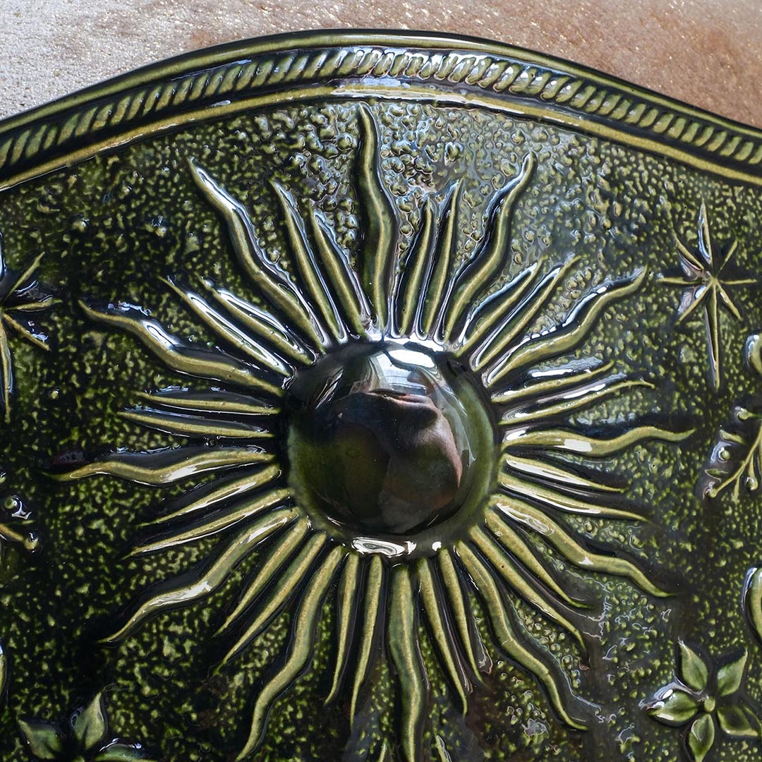 Détail soleil du tabouret Visconti en velours et porcelaine, émaillage vert. Création de mobilier sur mesure par l'atelier Ombre d'Or à Vincennes.