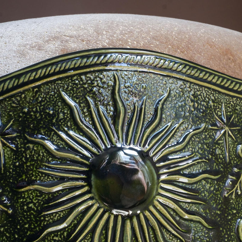 Détail soleil du tabouret Visconti en velours et porcelaine, émaillage vert. Création de mobilier sur mesure par l'atelier Ombre d'Or à Vincennes.