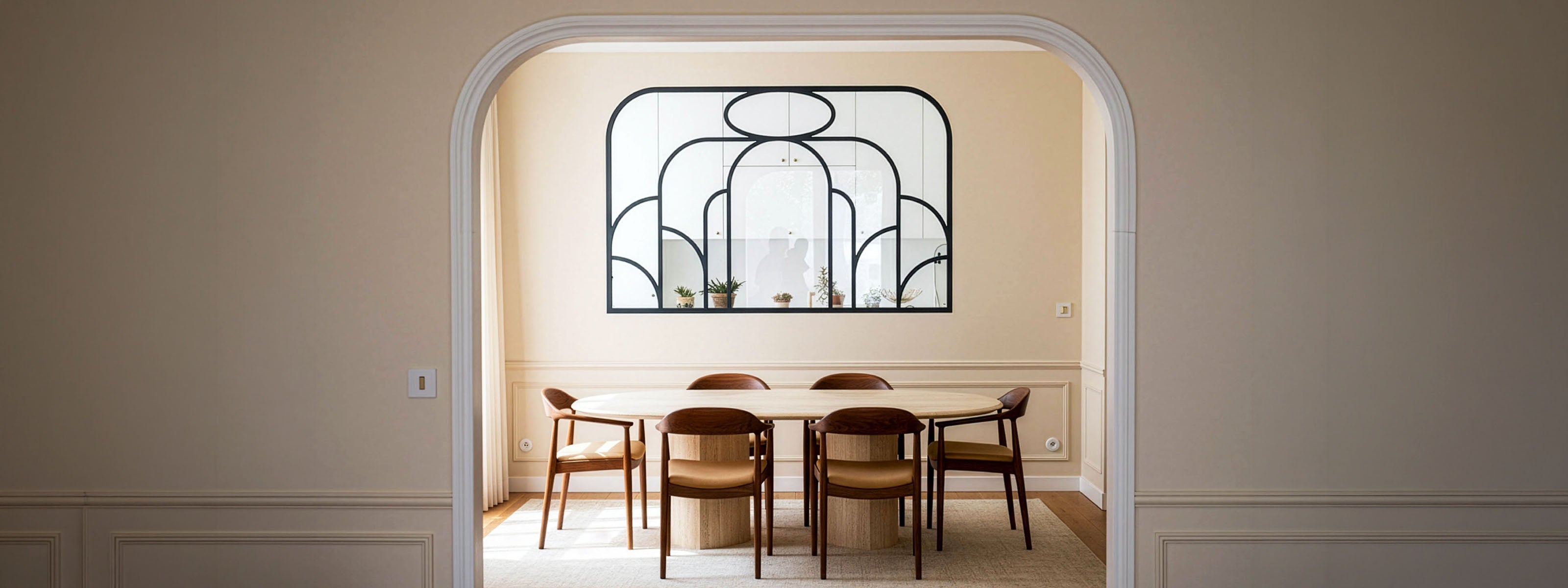 Architecture d’intérieur pour un projet à Saint-Mandé avec salle à manger minimaliste, verrière en métal noir sur mesure et mobilier aux lignes organiques dans un appartement rénové avec douceur.