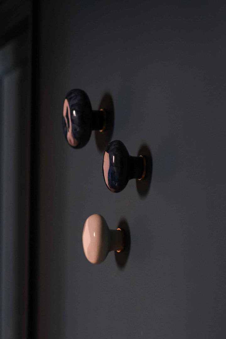Patères Agate en porcelaine cristallisée d'Ombre d'Or, installées dans le projet Convention : trois pièces signature aux émaux bleu nuit et rose poudré, dans un appartement haussmannien parisien.