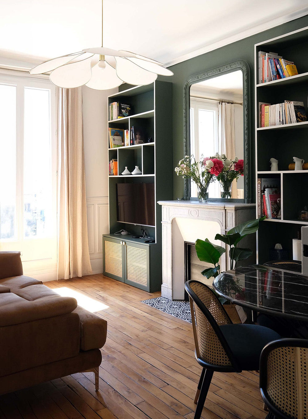 Appartement haussmannien rénové à Paris. Salon avec bibliothèque sur mesure vert profond, cheminée ancienne et décoration intérieure inspirée de la neuro architecture.