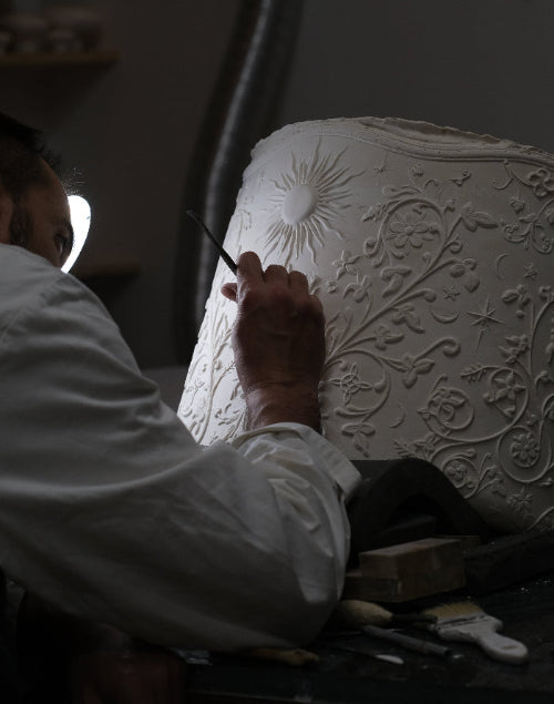 Création de mobilier sur mesure avec Yohann travaillant sur les motifs en relief de l'assise du tabouret Visconti.