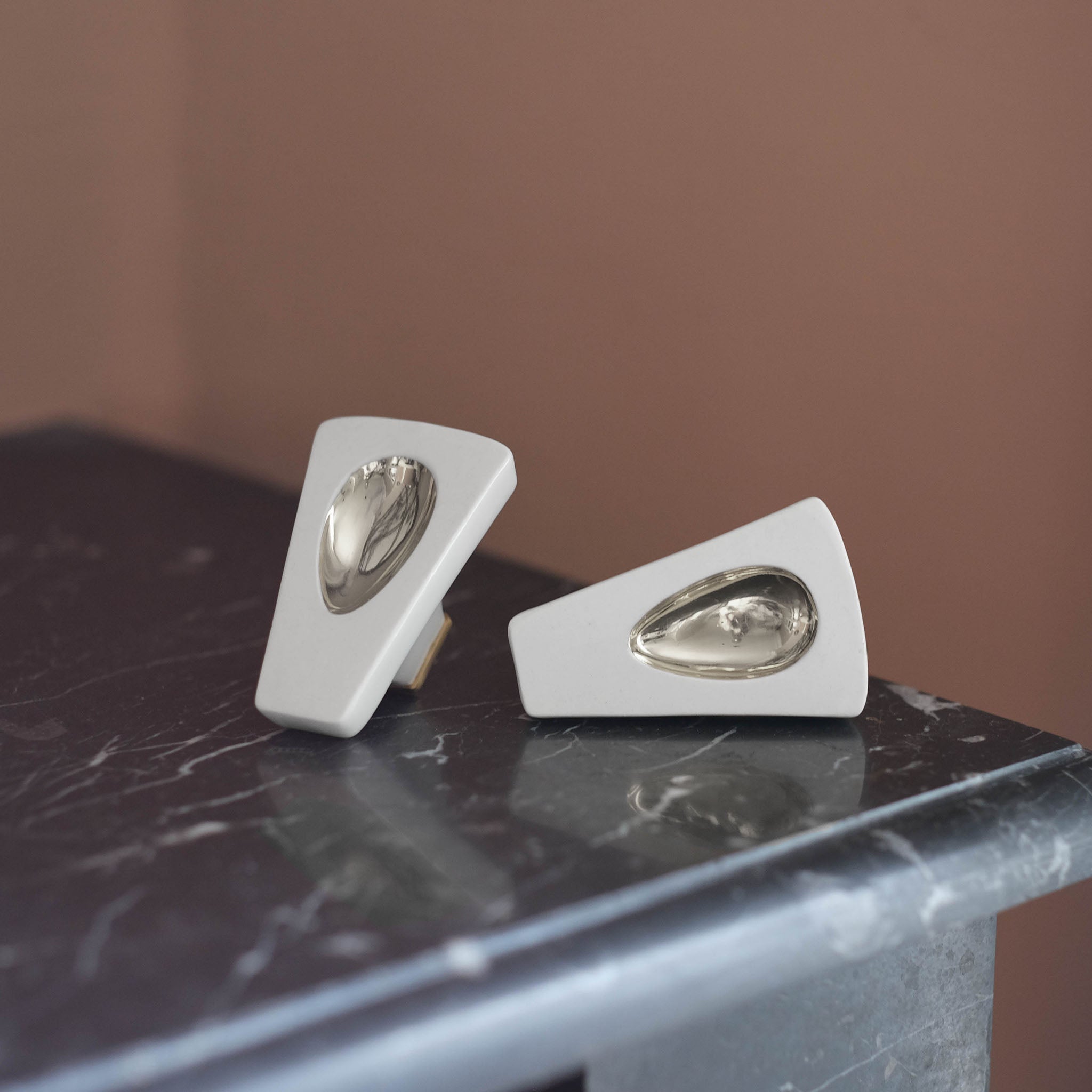  paires de boutons Ajna posés sur cheminée, couleurs platine. #couleur_platine