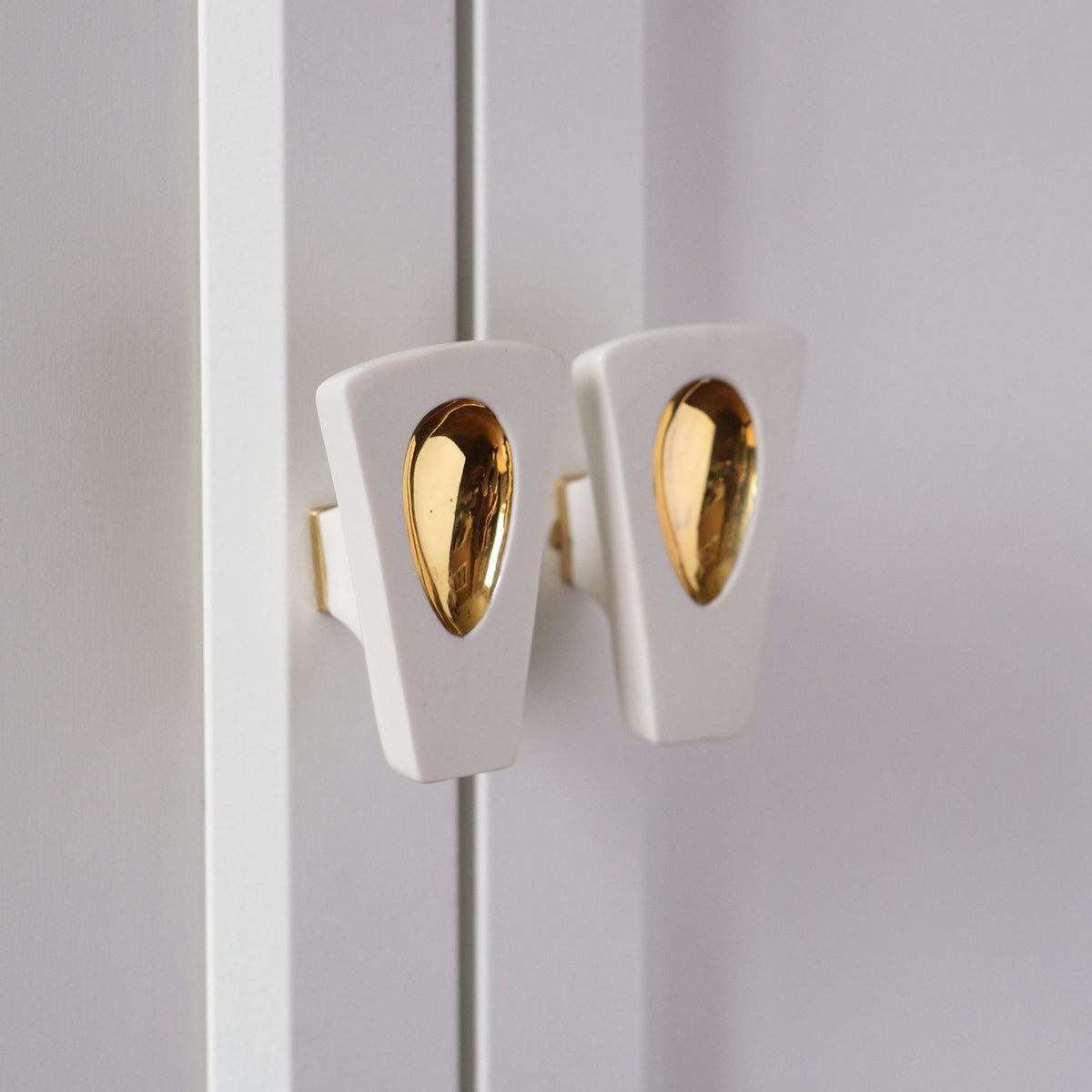  boutons Ajna installés sur meuble , vue de profil. #couleur_or