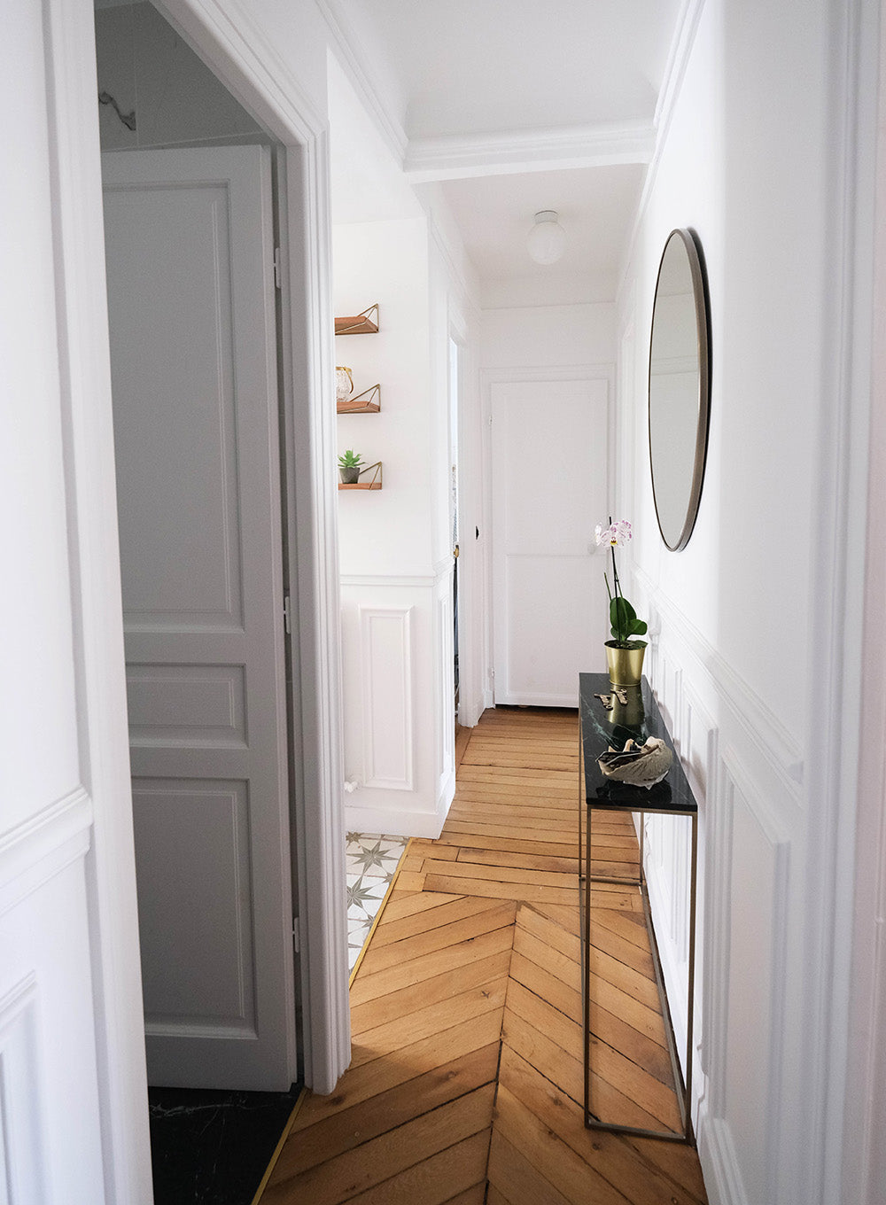 Appartement avec couloir haussmannien rénové à Paris. Parquet ancien, décoration minimaliste et architecture intérieure lumineuse.