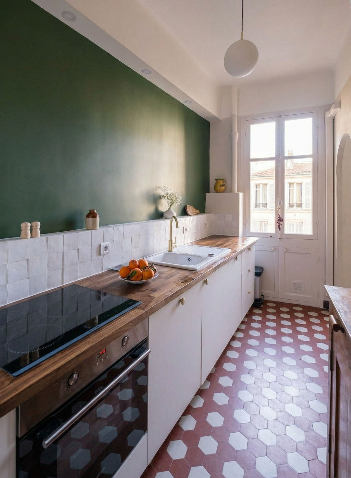 Cuisine étroite optimisée, crédence en zellige et mur vert profond, aux inspirations méditerranéennes. Projet d'architecture d'intérieur à Nice.