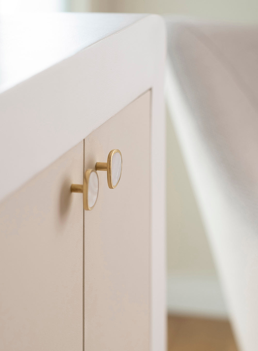 Détail de boutons de meuble en porcelaine intégrés à un cabinet thérapeutique à Paris suite à un travail d'architecture d’intérieur dans une ambiance minimaliste et haut de gamme.