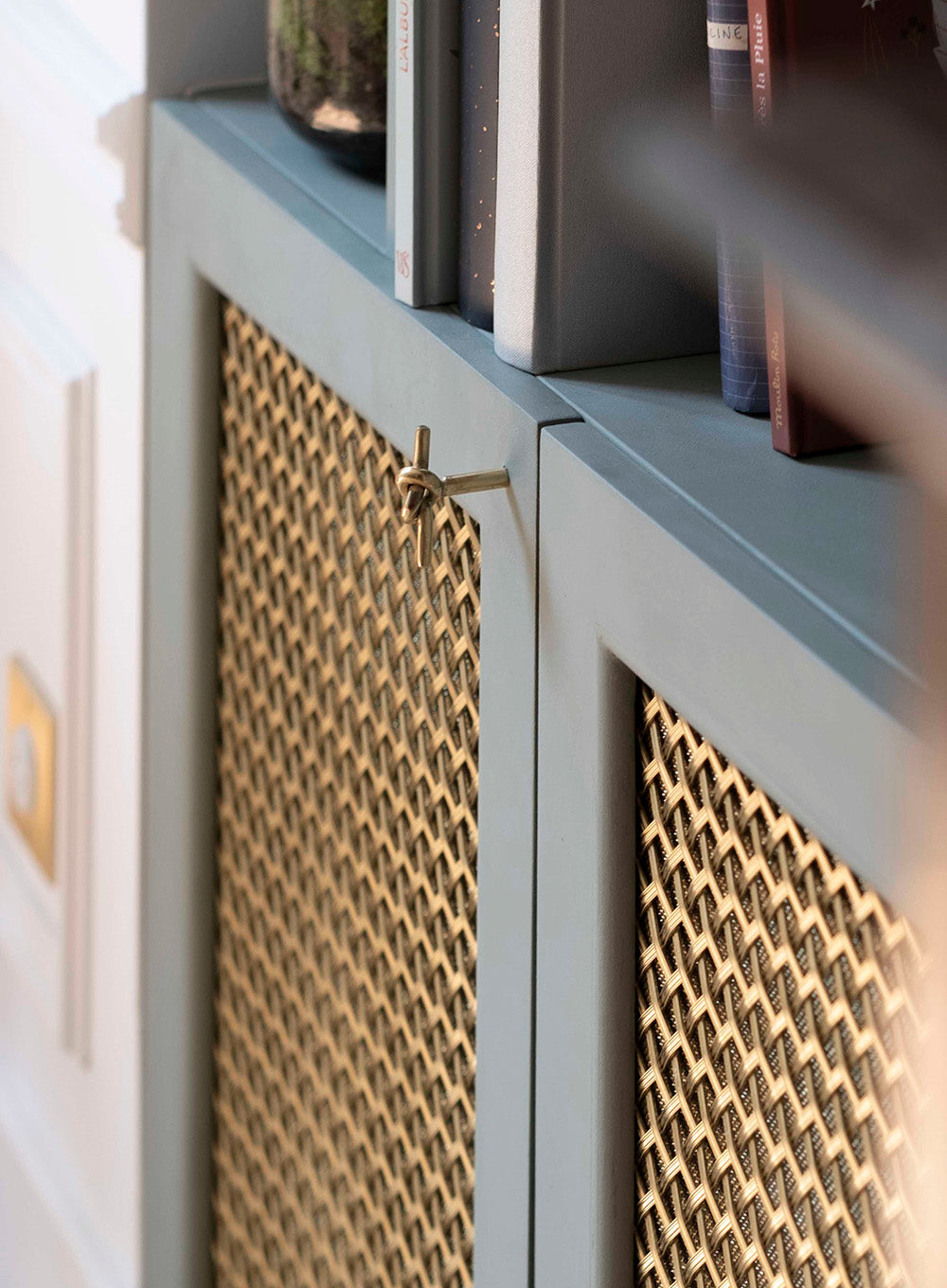 Détail de bibliothèque, création de mobilier sur mesure avec cannage intégré dans un projet d’architecture intérieure et d’agencement haut de gamme à Paris.