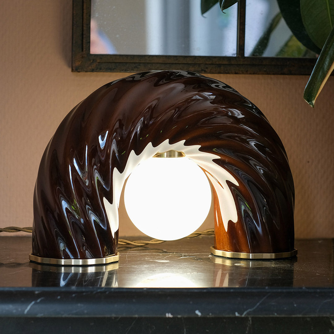 Lampe à poser L'Impiccato en laiton et porcelaine, version allumée. Création par l'atelier Ombre d'Or à Vincennes.