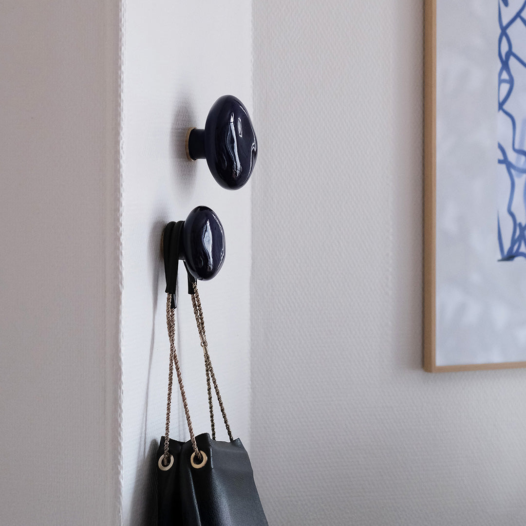 Deux patères Agate bleues "sèvres" en porcelaine émaillée, installées sur un mur blanc  et avec un sac a main accroché #couleur_bleu sèvres