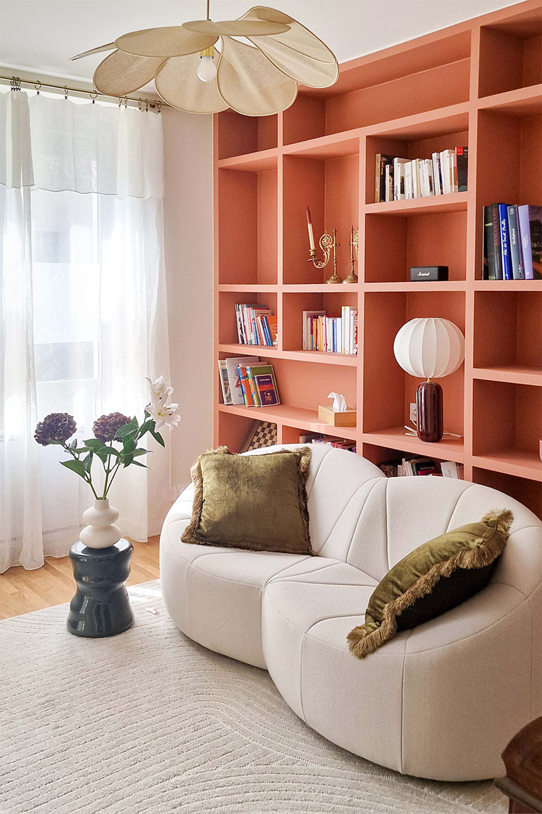 Architecture d'intérieur pour un appartement transformé en cabinet de psychologie à Paris avec bibliothèque sur mesure terracotta, mobilier courbe et design d’intérieur chaleureux pour une salle de consultation apaisante.