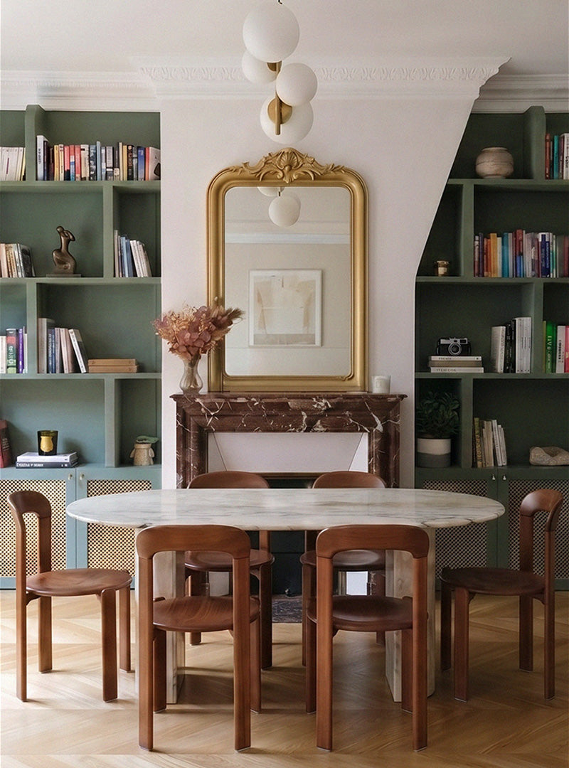Salle à manger du projet Convention à Paris avec bibliothèque intégrée vert sauge, cheminée en marbre et aménagement sur mesure conçu par Ombre d'Or.