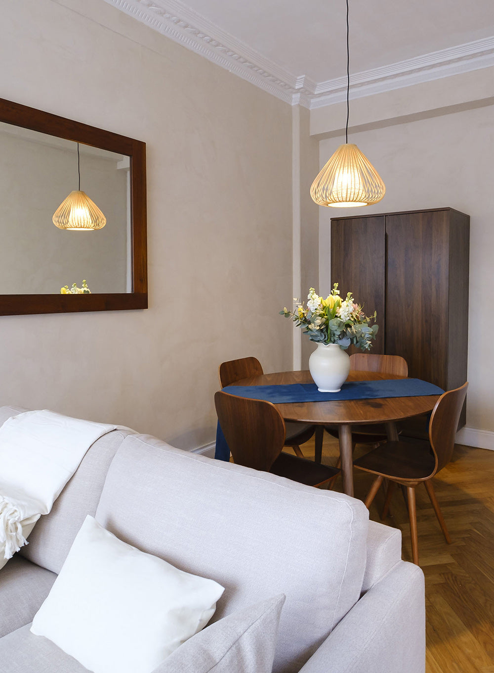 Aménagement intérieur d’un appartement à Nice avec salle à manger chaleureuse, parquet ancien et décoration naturelle.
