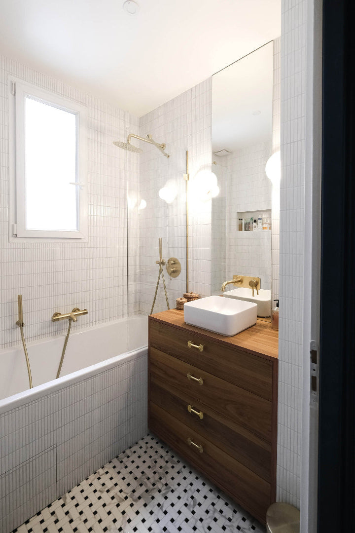 Salle de bain d'un appartement parisien, projet Cels par Ombre d'Or : douche italienne, robinetterie laiton, faïence métro blanche et meuble vasque en noyer.