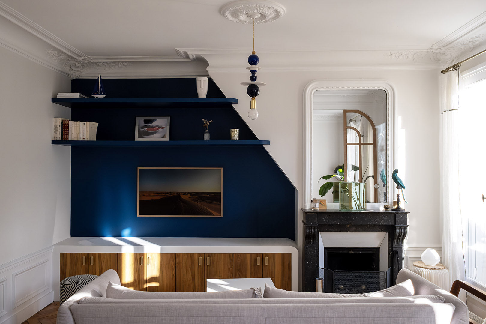 Projet d’architecture intérieure à Paris avec salon ancien rénové, bibliothèque sur mesure bleu profond et décoration intérieure contemporaine.