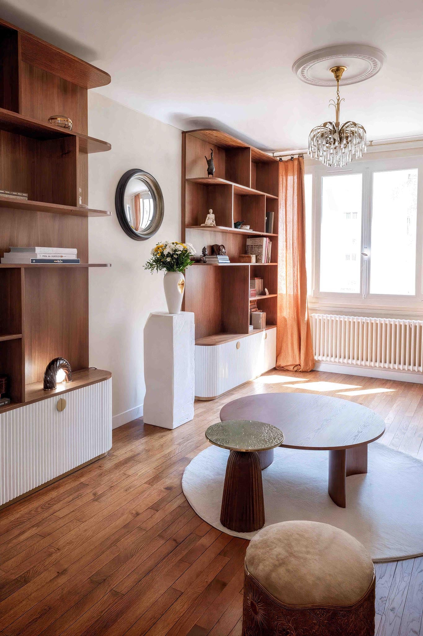 Salon rénové à Saint Mandé avec bibliothèque sur mesure en noyer, rangements cannelés, création de mobilier sur mesure pour une décoration intérieure unique et organique.