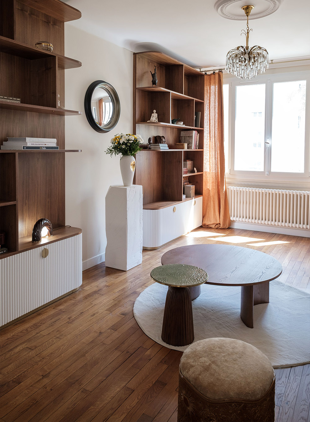 Salon rénové à Saint Mandé avec bibliothèque sur mesure en noyer, rangements cannelés, création de mobilier sur mesure pour une décoration intérieure unique et organique.