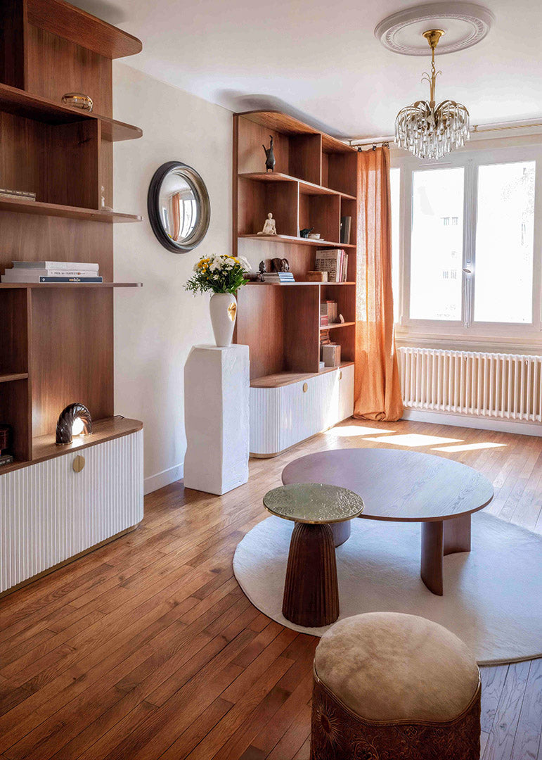 Salon rénové à Saint Mandé avec bibliothèque sur mesure en noyer, rangements cannelés, création de mobilier sur mesure pour une décoration intérieure unique et organique.