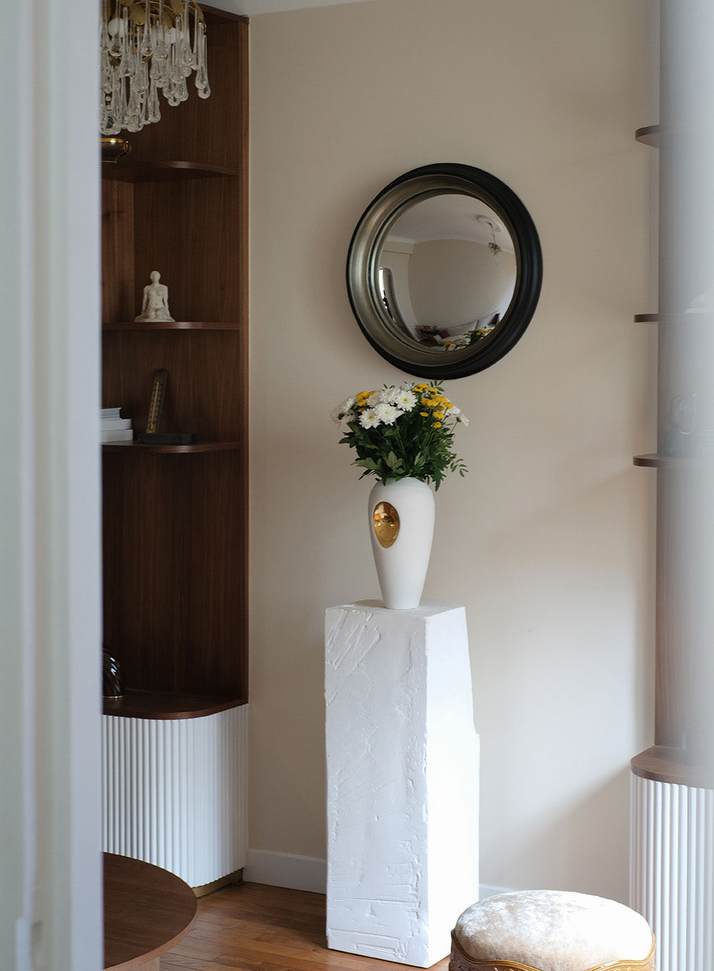Projet d’architecture d’intérieur à Saint Mandé. Détail du salon avec miroir convexe pensé pour agrandir visuellement l’espace, mobilier intégré et vase en céramique crée sur mesure.