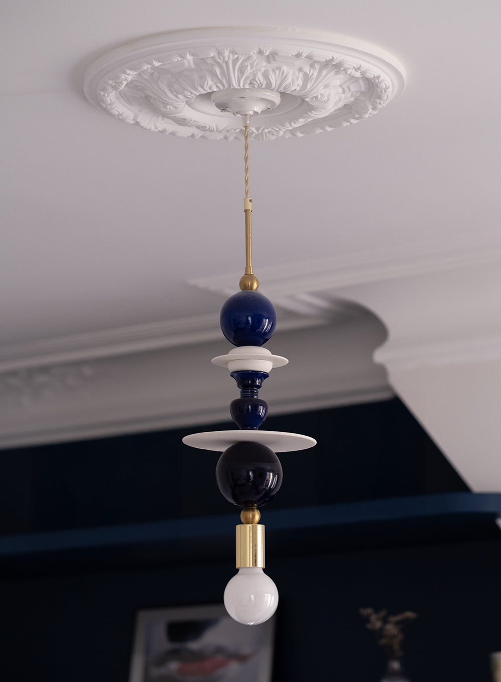Suspension design en porcelaine bleue et laiton doré. Création sur mesure pour un appartement haussmannien rénové avec une décoration intérieure contemporaine.