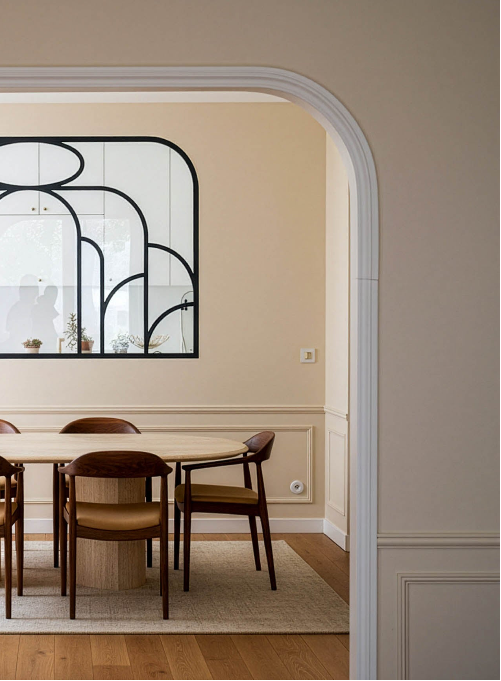 Rénovation intérieure à Saint Mandé avec salle à manger ouverte, arche architecturale et verrière en métal créant une continuité fluide entre les pièces.